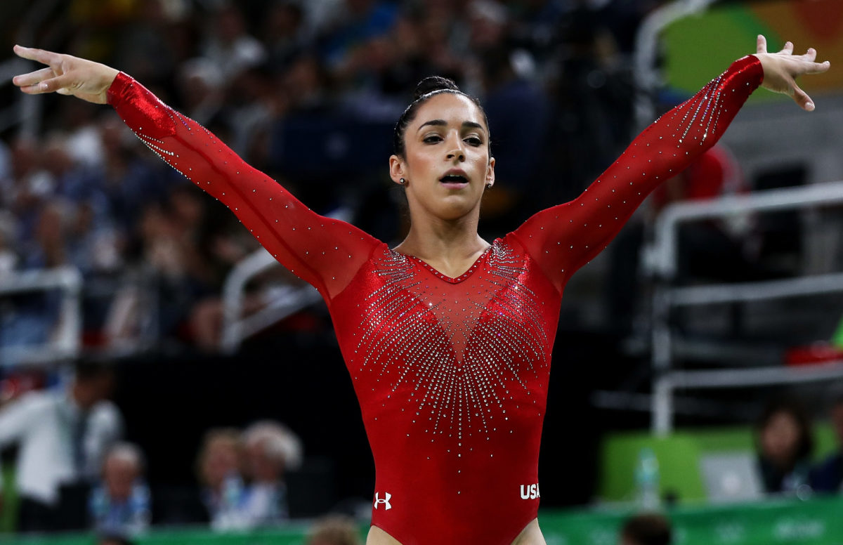 Aly Raisman with her arms up after completing the balance beam.