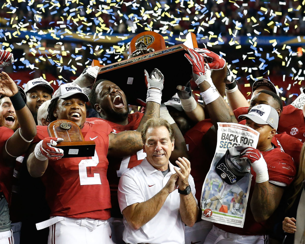 Members of the Alabama Crimson Tide, including running back Derrick Henry #2 (front, left) and head coach Nick Saban (center) celebrate after the SEC Championship game.