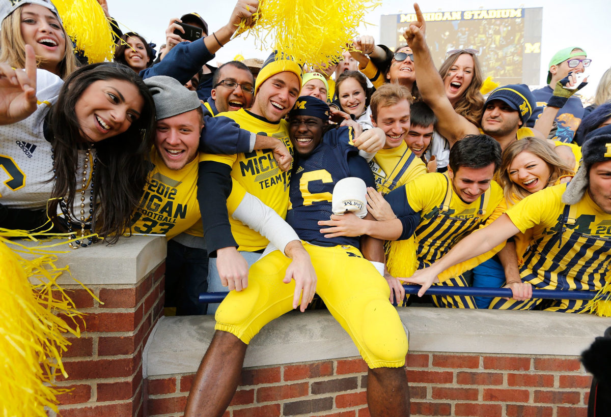 Michigan star Denard Robinson celebrates with Wolverines fans.