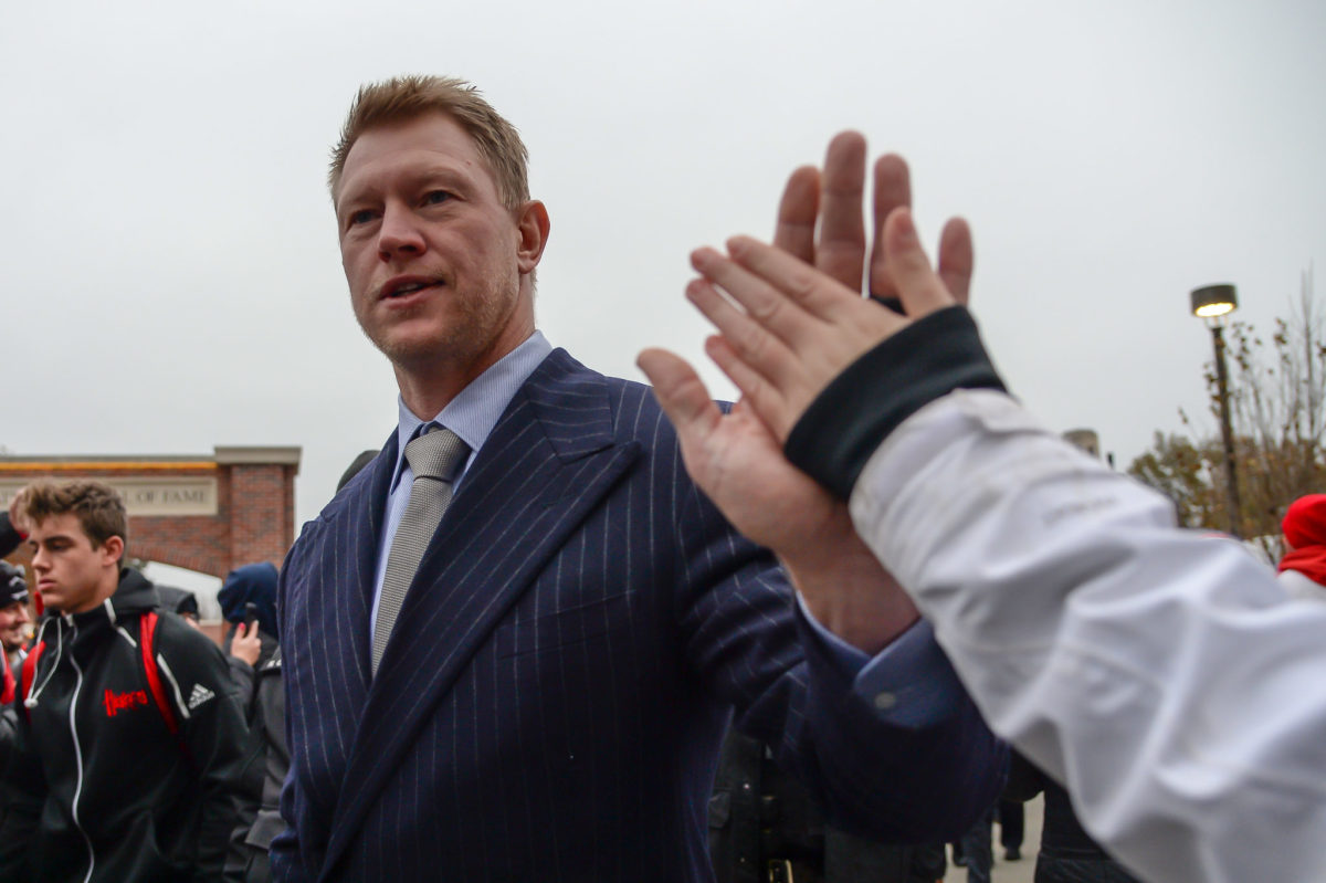 Scott Frost greeting fans as the team arrives to its football game.