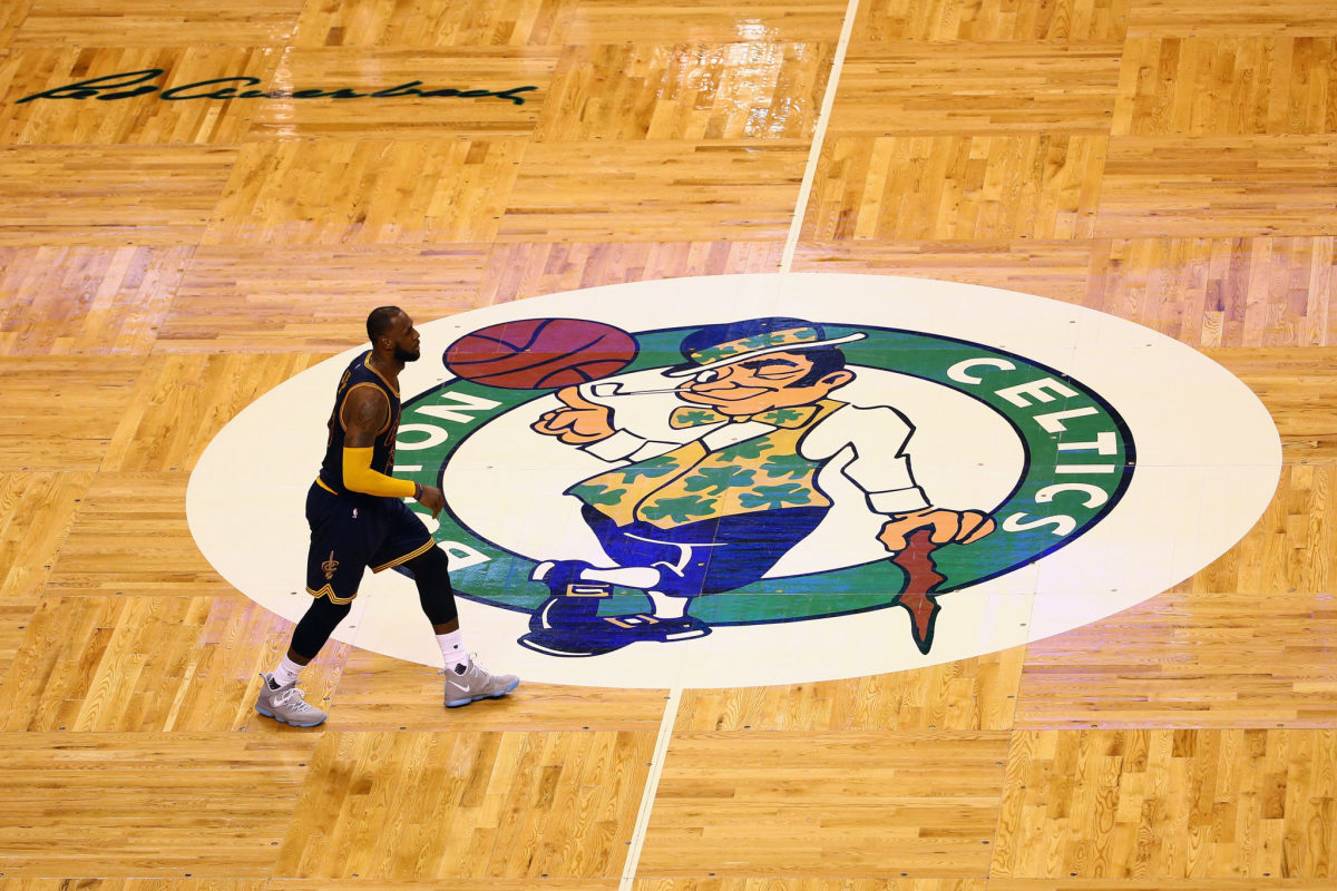 LeBron James standing at the center of the Boston Celtics home court.