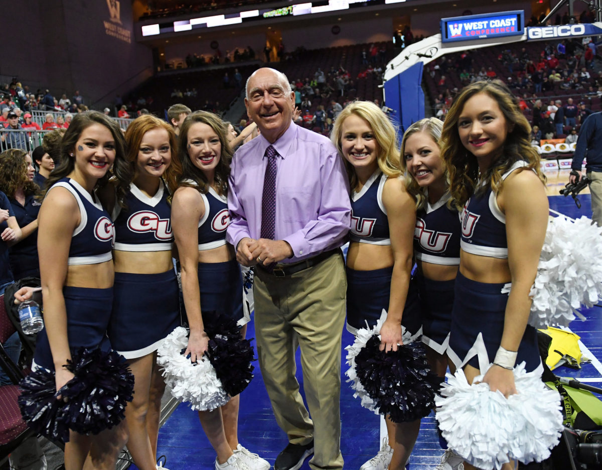 Dick Vitale standing with Gonzaga cheerleaders.