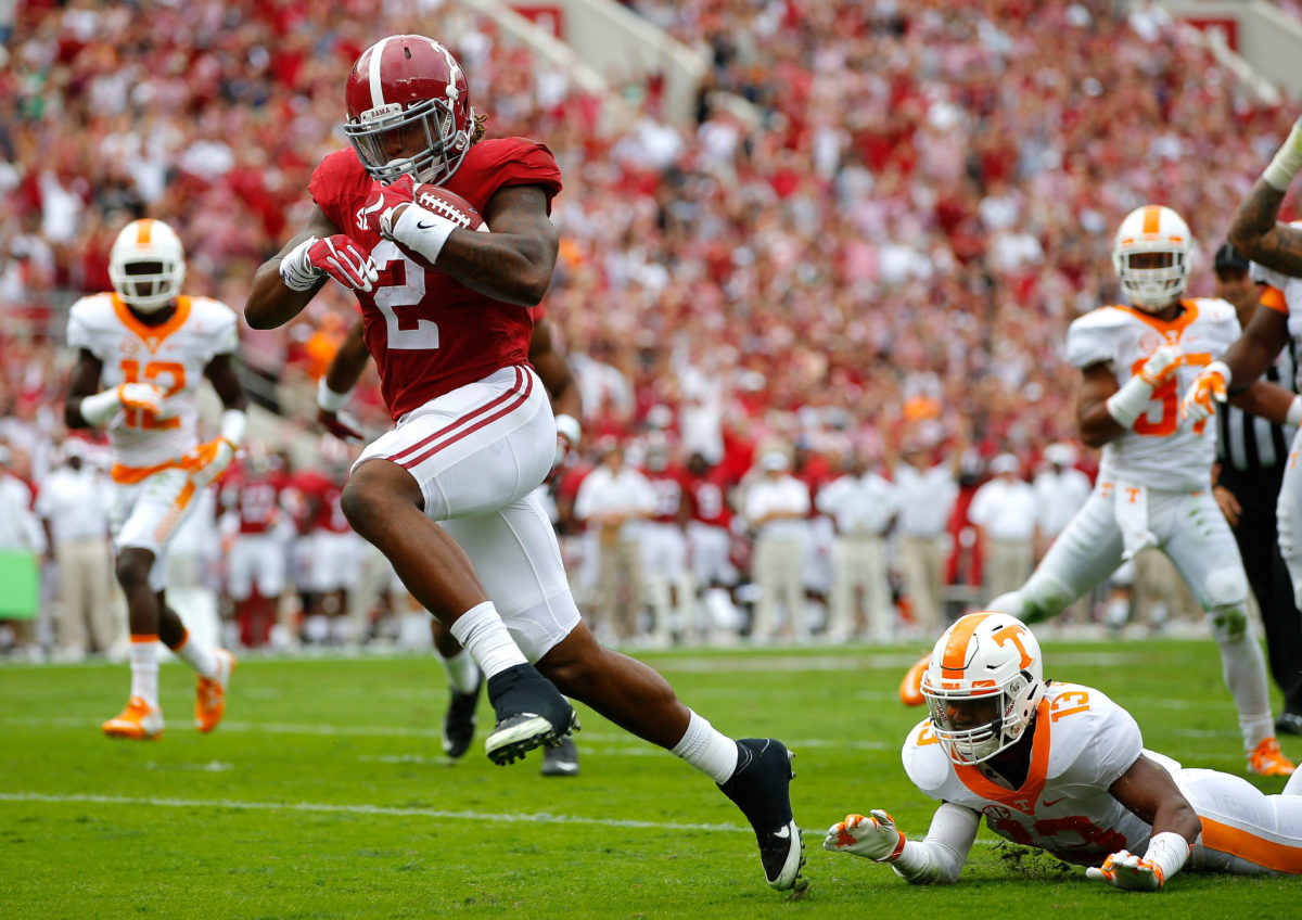 Derrick Henry of the Alabama Crimson Tide rushes in for a touchdown as he breaks a tackle by Malik Foreman #13 of the Tennessee Volunteers at Bryant-Denny Stadium.
