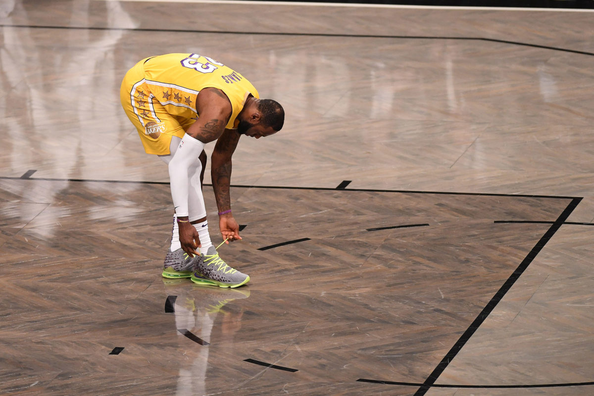LeBron James ties his shoes during a game in Brooklyn.