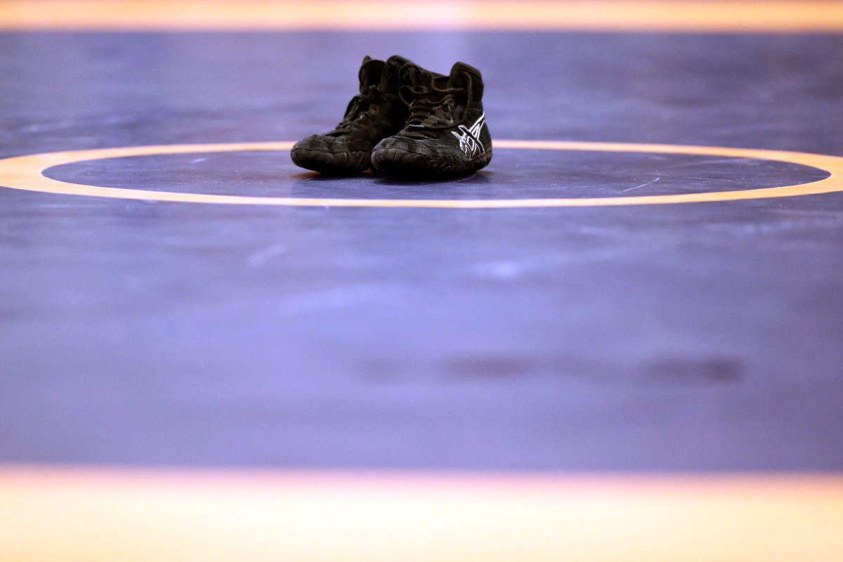 A generic picture of wrestling shoes on a wrestling mat.