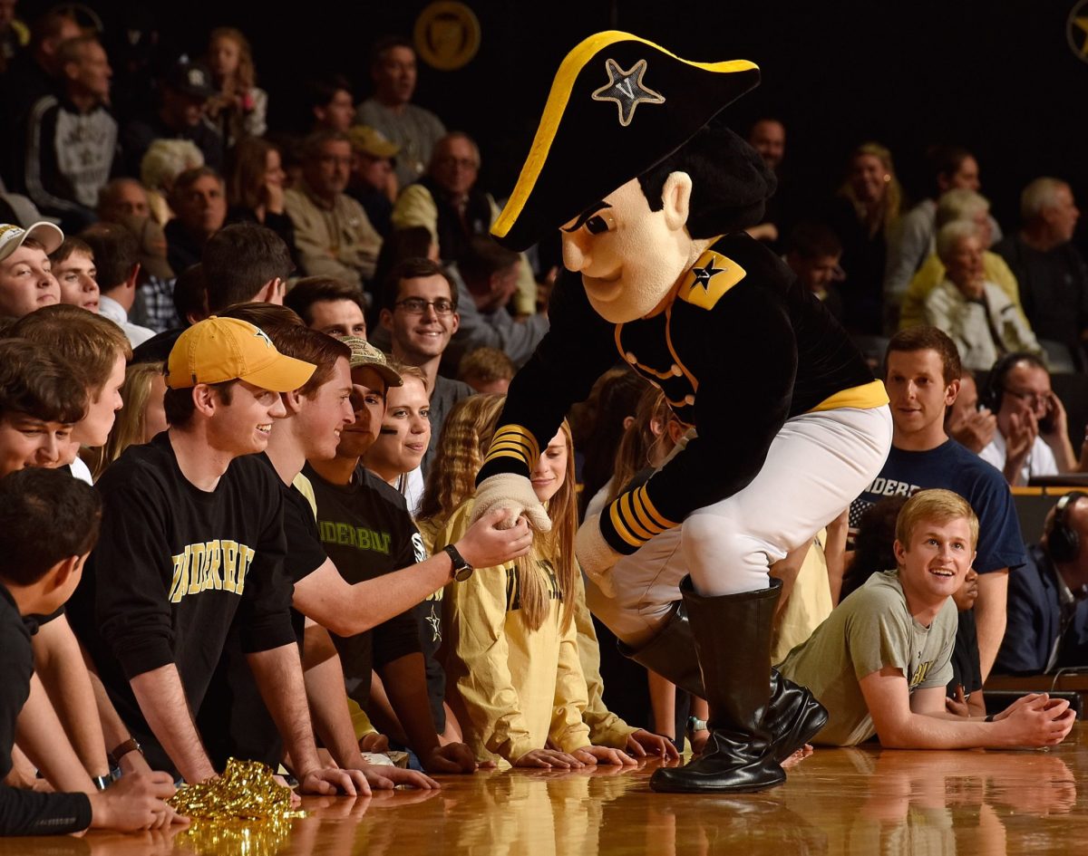 Vanderbilt's mascot shaking a student's hand.