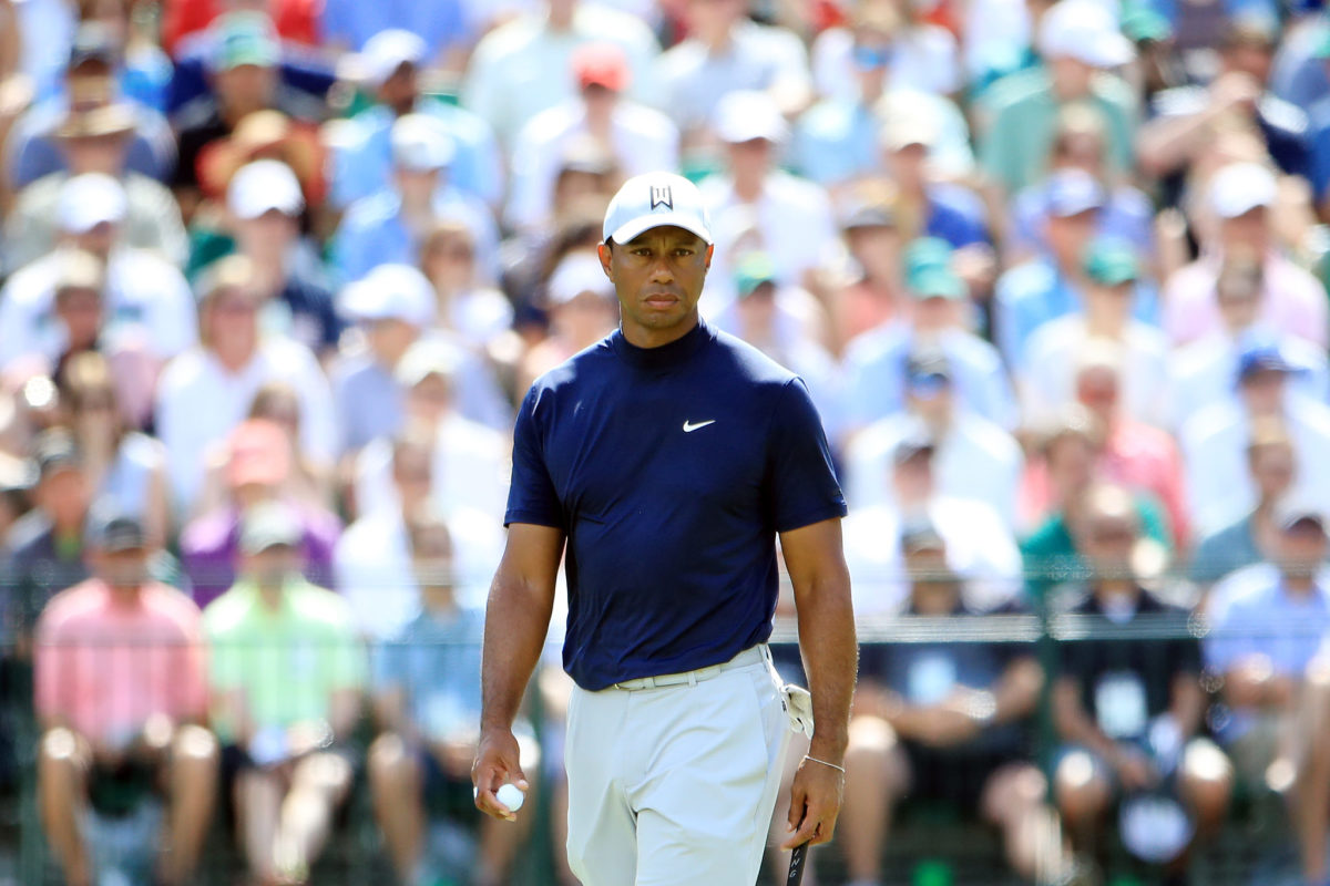 Tiger Woods stands on the green.