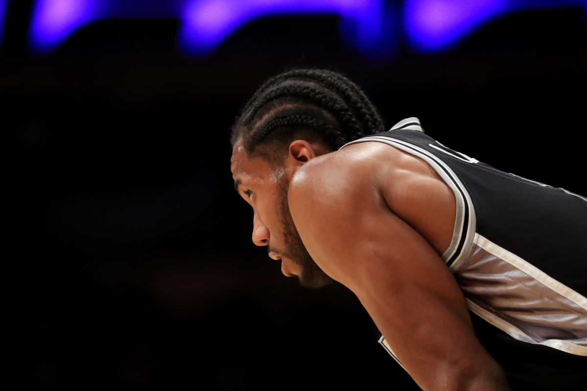 A view of Kawhi Leonard crouching down from the side.