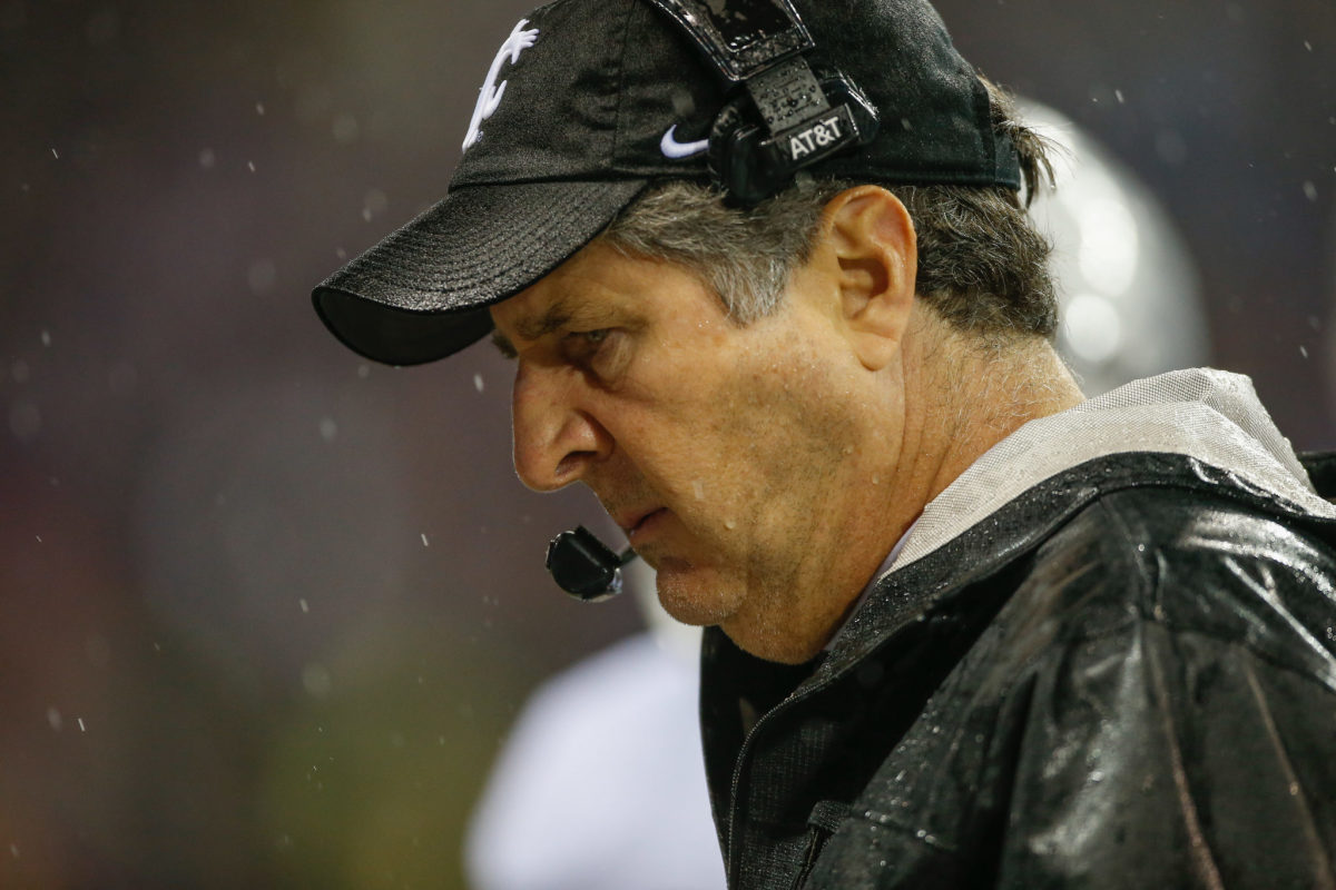 Mike Leach looks on as the rains come down.