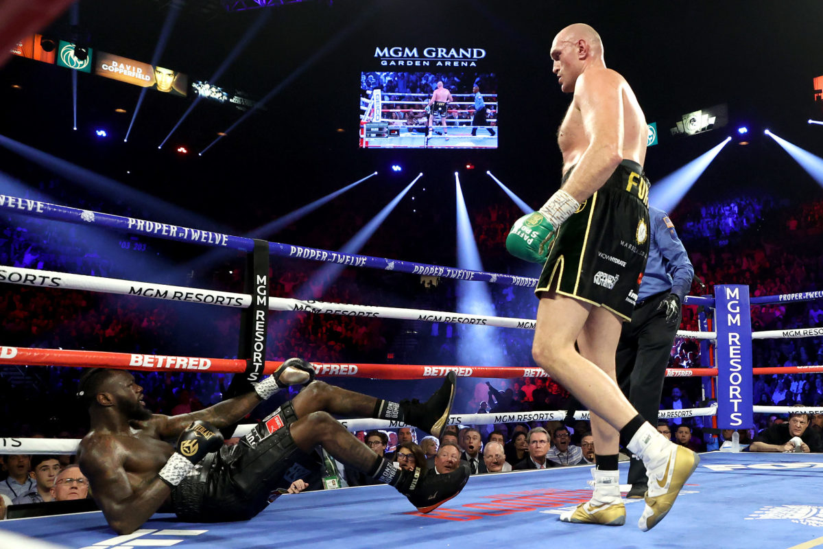 Tyson Fury stands over Deontay Wilder after knocking him down during their second fight.