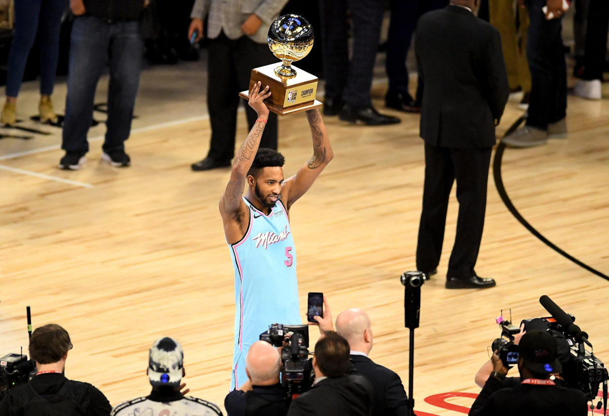 Miami Heat wing Derrick Jones Jr. hoists NBA Dunk Contest trophy.