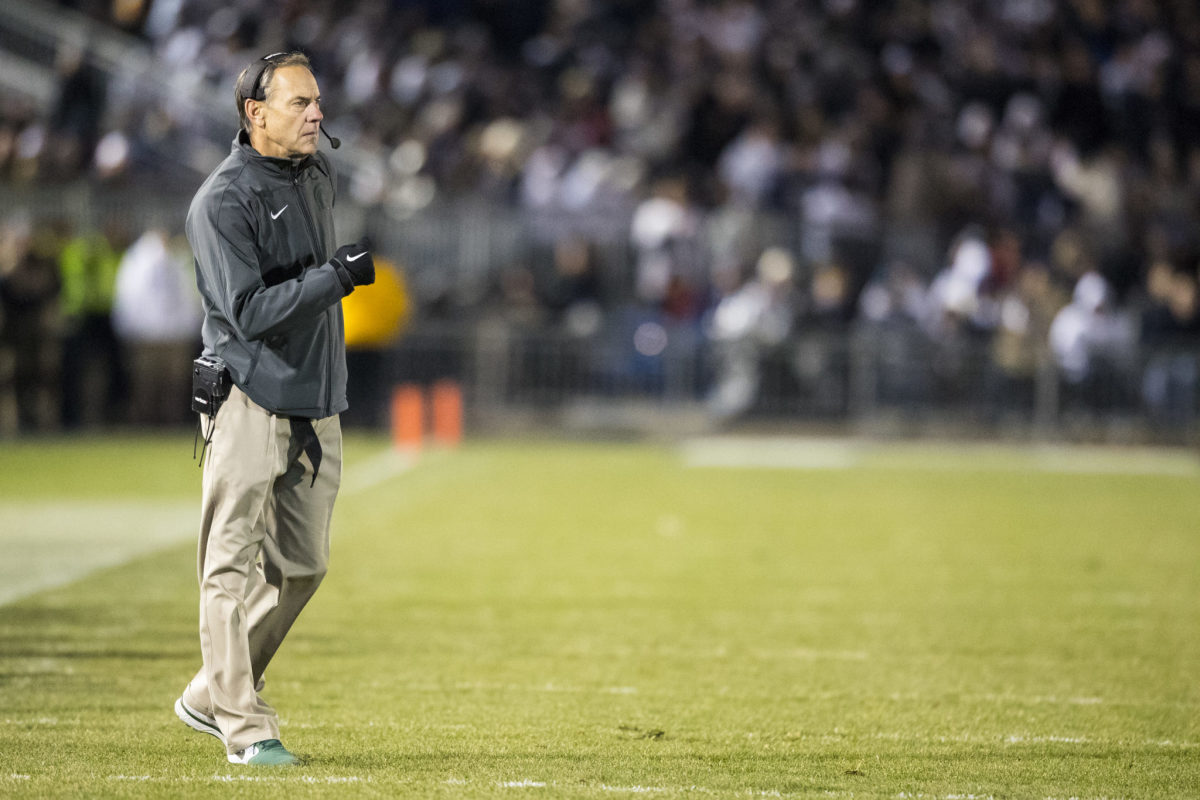 Mark Dantonio walking onto the field during a Michigan State football game.