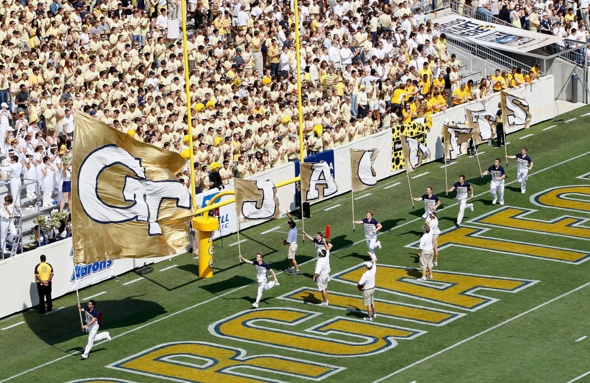 Georgia Tech cheerleaders running on the football field.