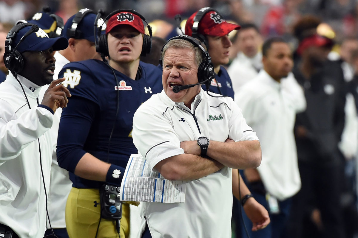 Brian Kelly with his arms crossed on the Notre Dame sideline.