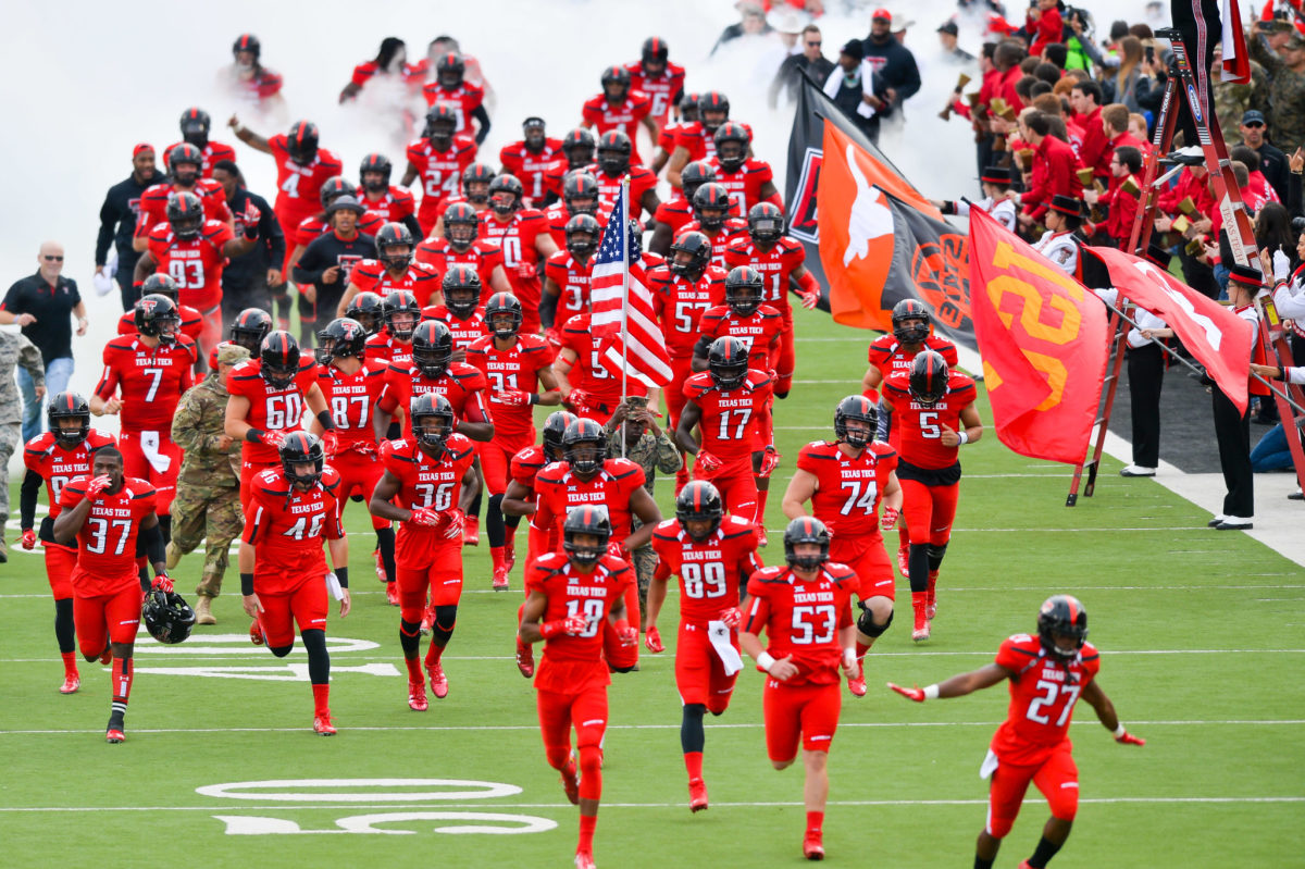 Texas Tech's football team running onto the field for a Big 12 football game.