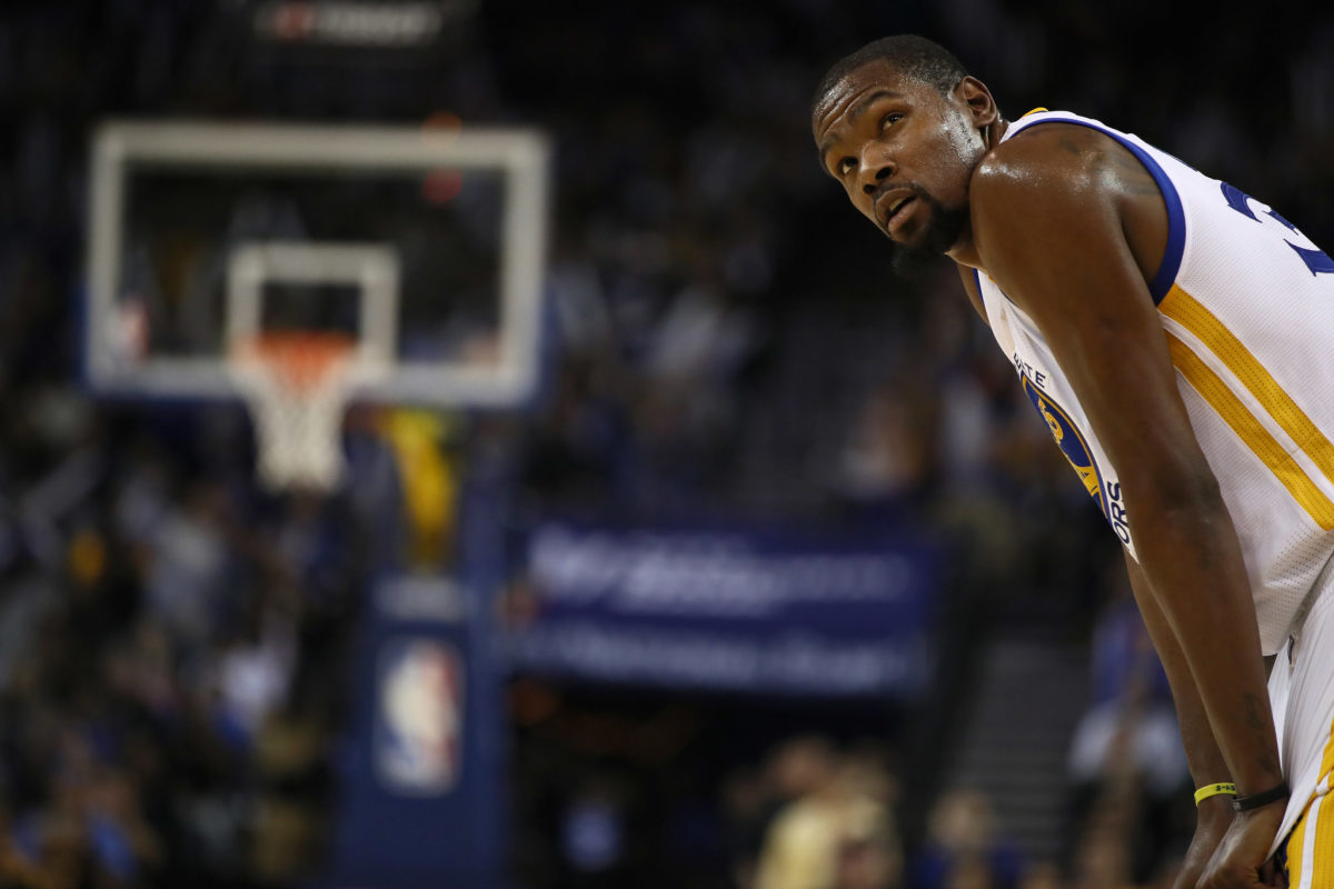 Kevin Durant hunched over in his Golden State Warriors uniform.