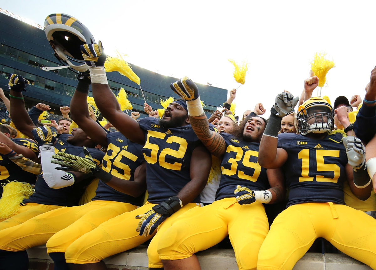 Michigan football players interacting with fans.