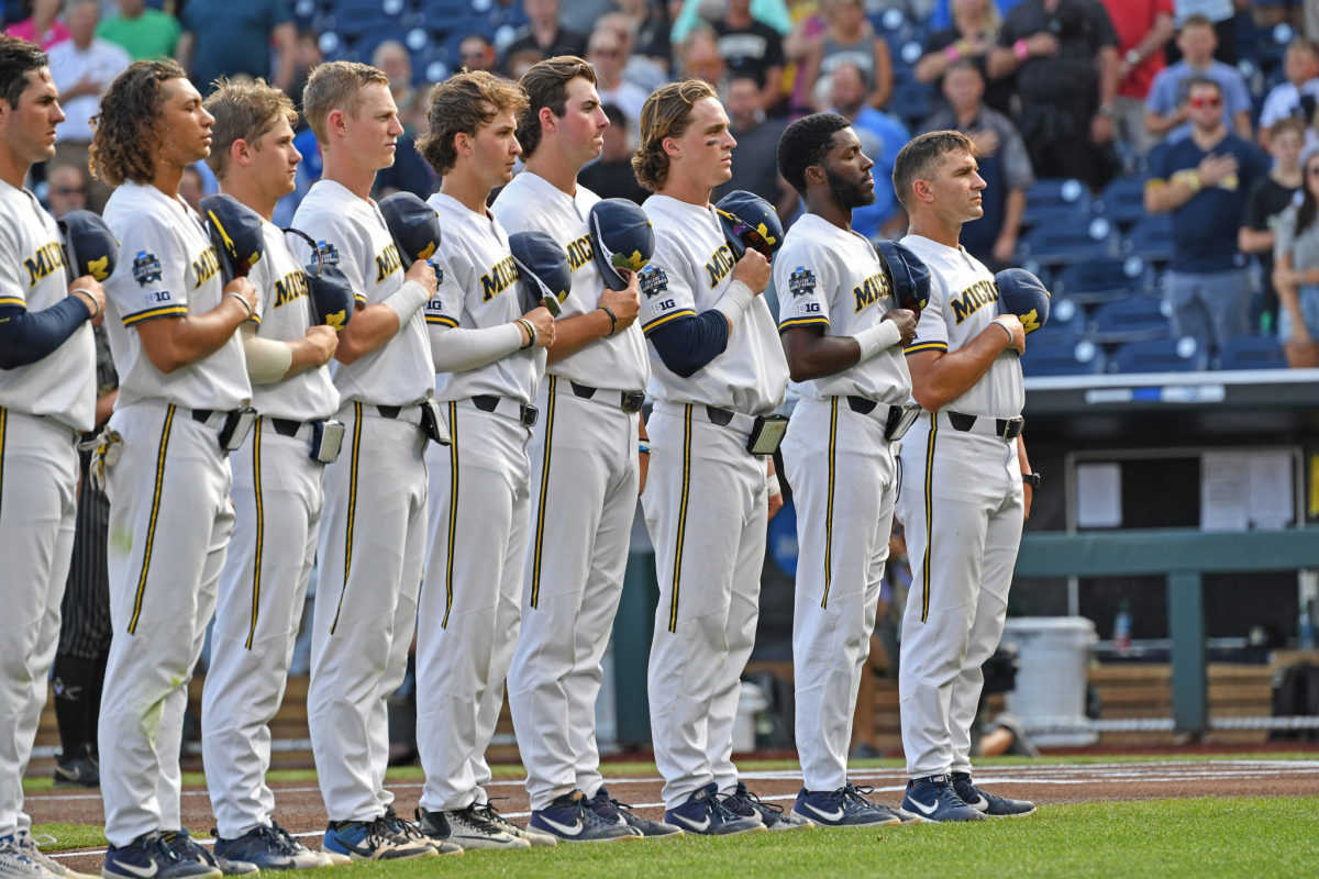 Michigan baseball players stand during the National Anthem.