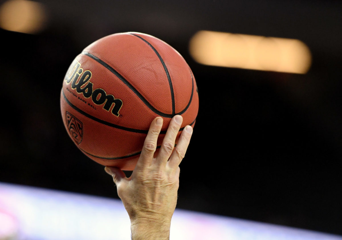 A referee holds up a basketball during a first-round game of the Pac-12 Basketball Tournament between the Washington State Cougars and the Colorado Buffaloes.