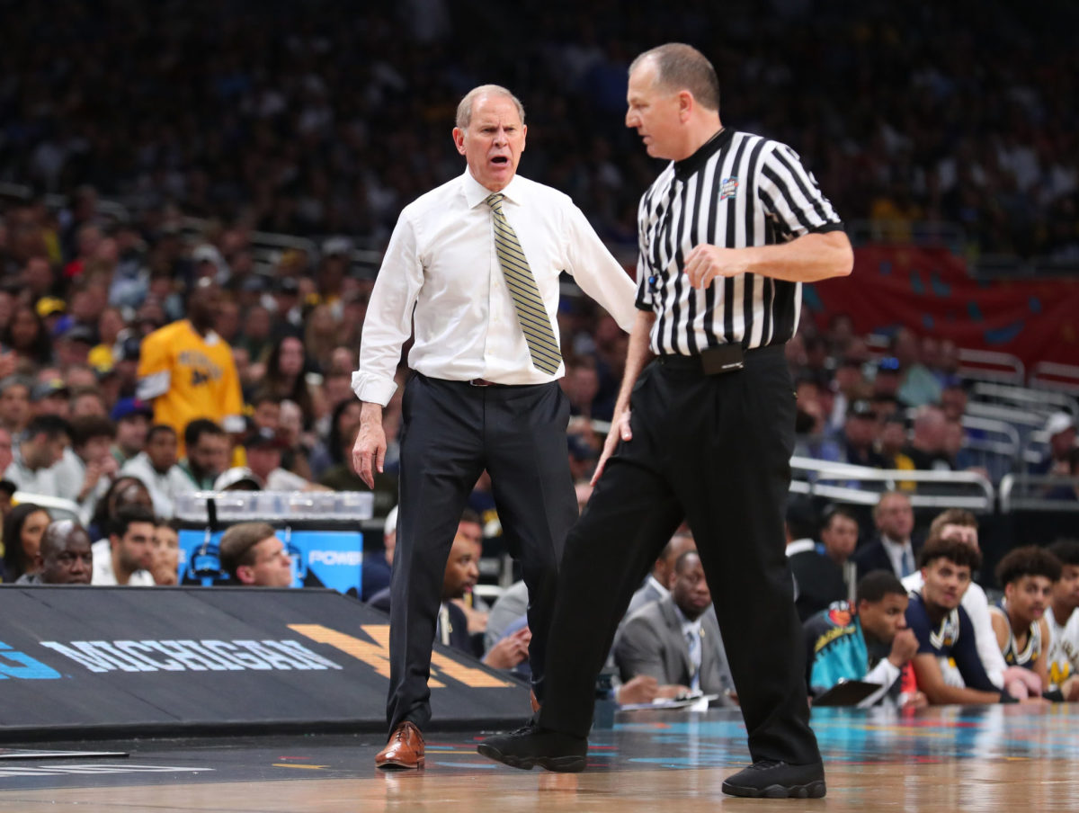 Head coach John Beilein of the Michigan Wolverines complains to the referee against the Villanova Wildcats.
