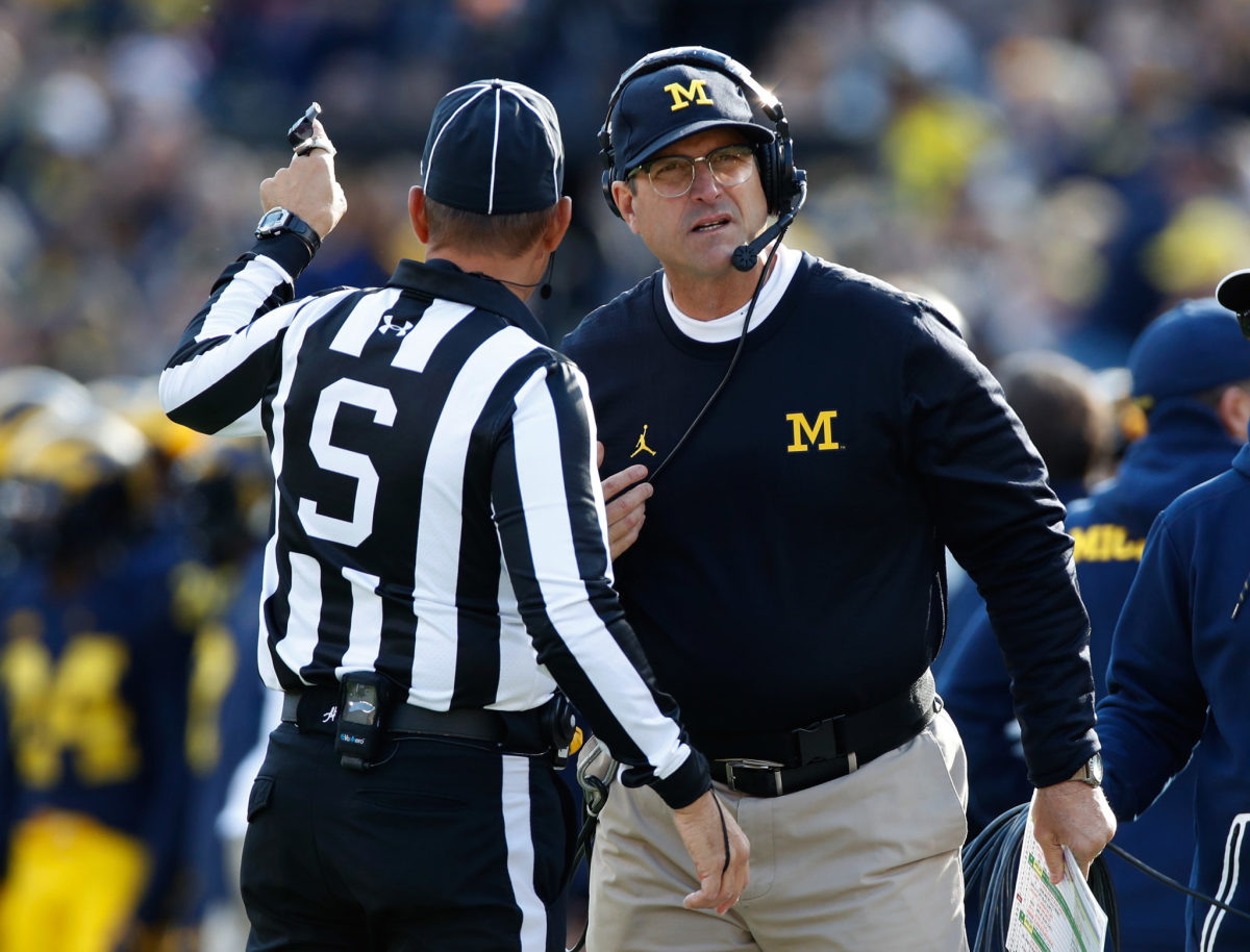 Jim Harbaugh talking to a referee during a Michigan football game.