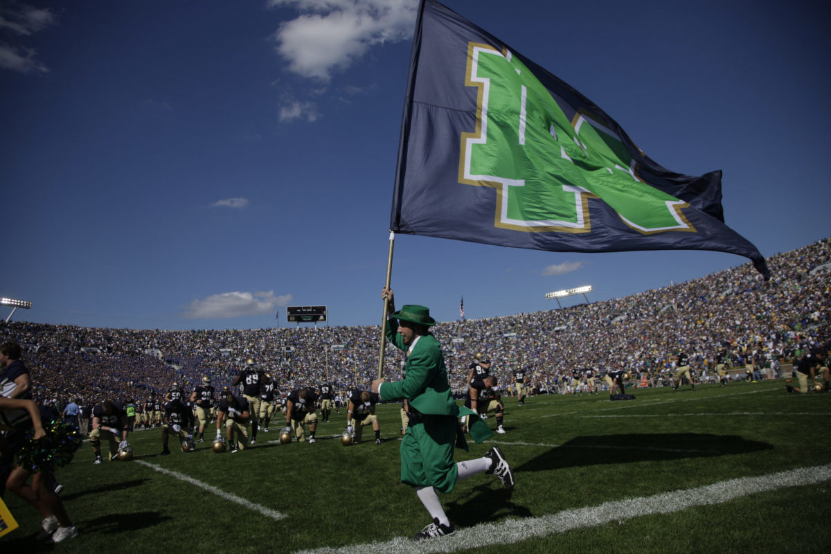 Notre Dame's mascot running with a flag.