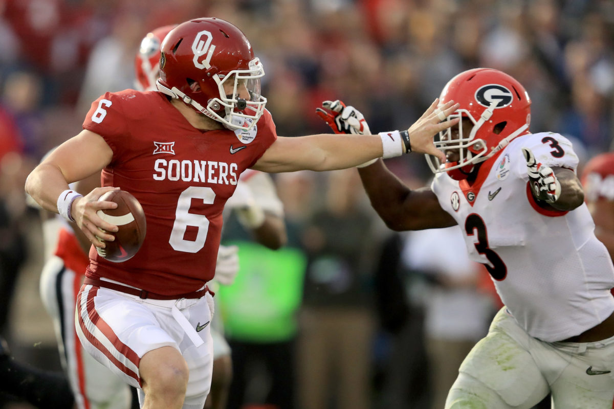 Quarterback Baker Mayfield #6 of the Oklahoma Sooners looks to avoid a sack by linebacker Roquan Smith #3 of the Georgia Bulldogs.