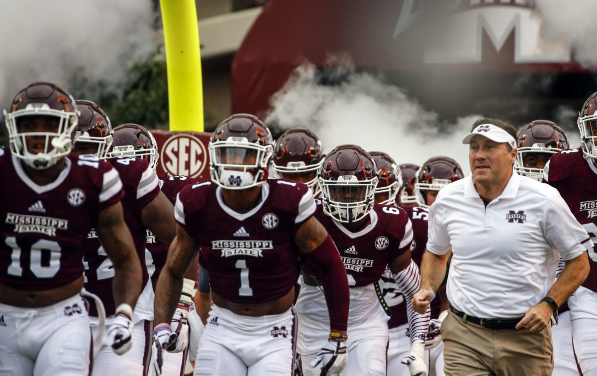 Dan Mullen leading his Mississippi State players onto the field.