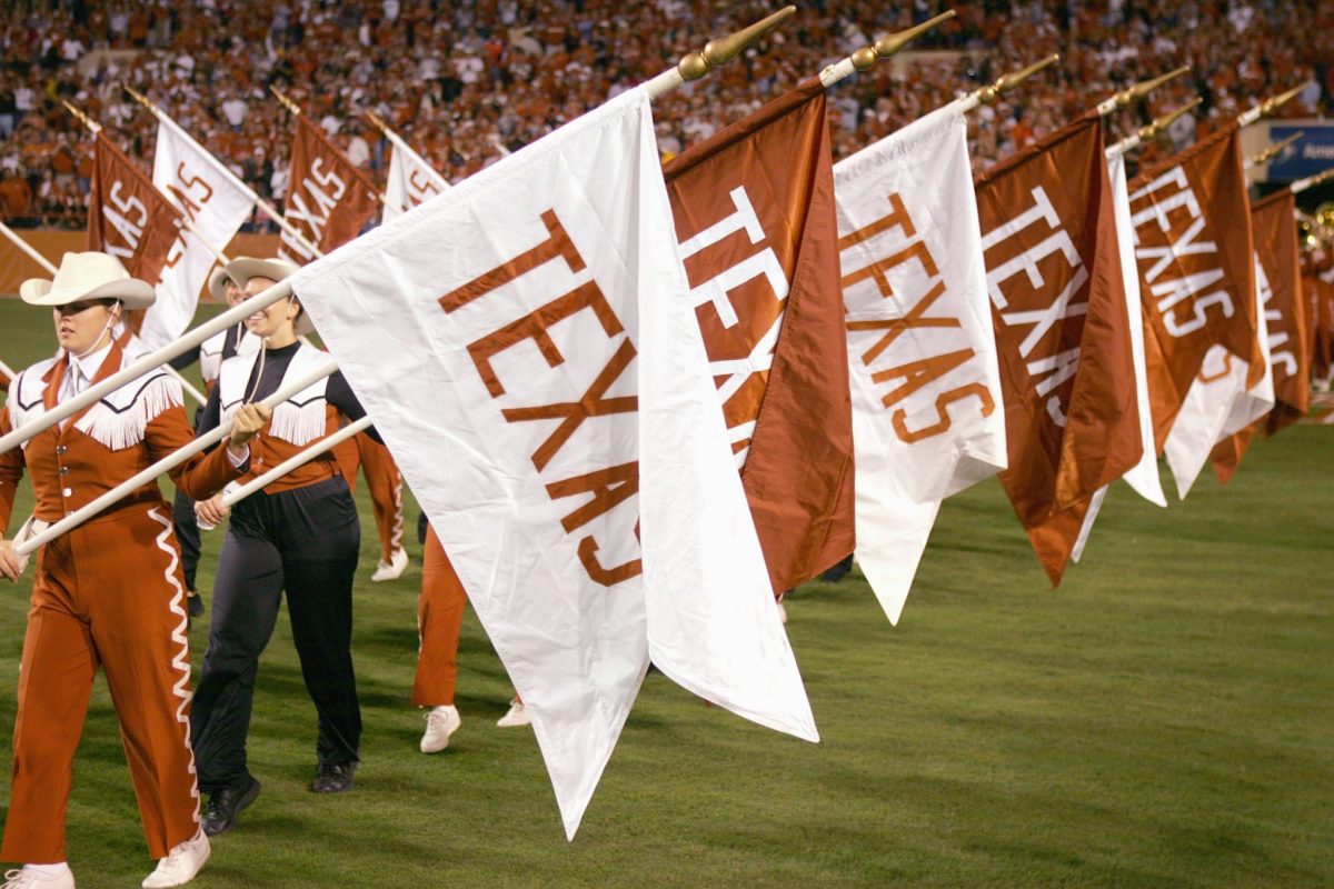 Texas Longhorns cheerleaders holding flags.