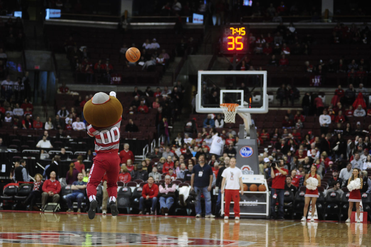 Ohio State's mascot taking a half court shot during a basketball game.