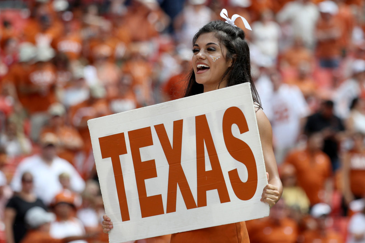 A cheerleader holding up a Texas sign.