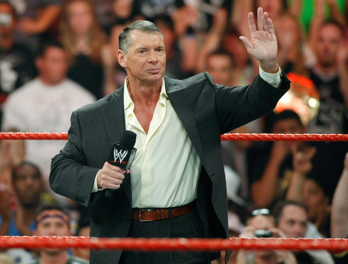 Vince McMahon speaking to fans while standing in a WWE ring.