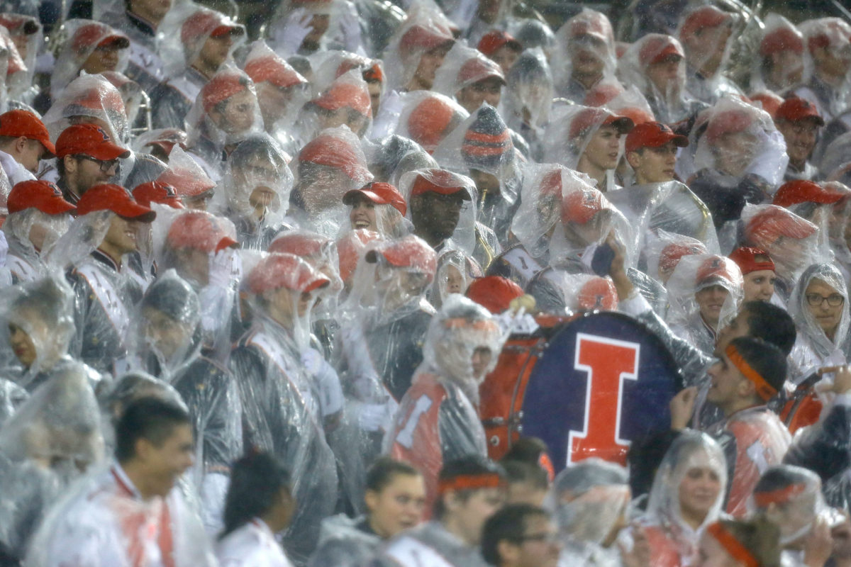 Illinois football fans watching the game in the rain.