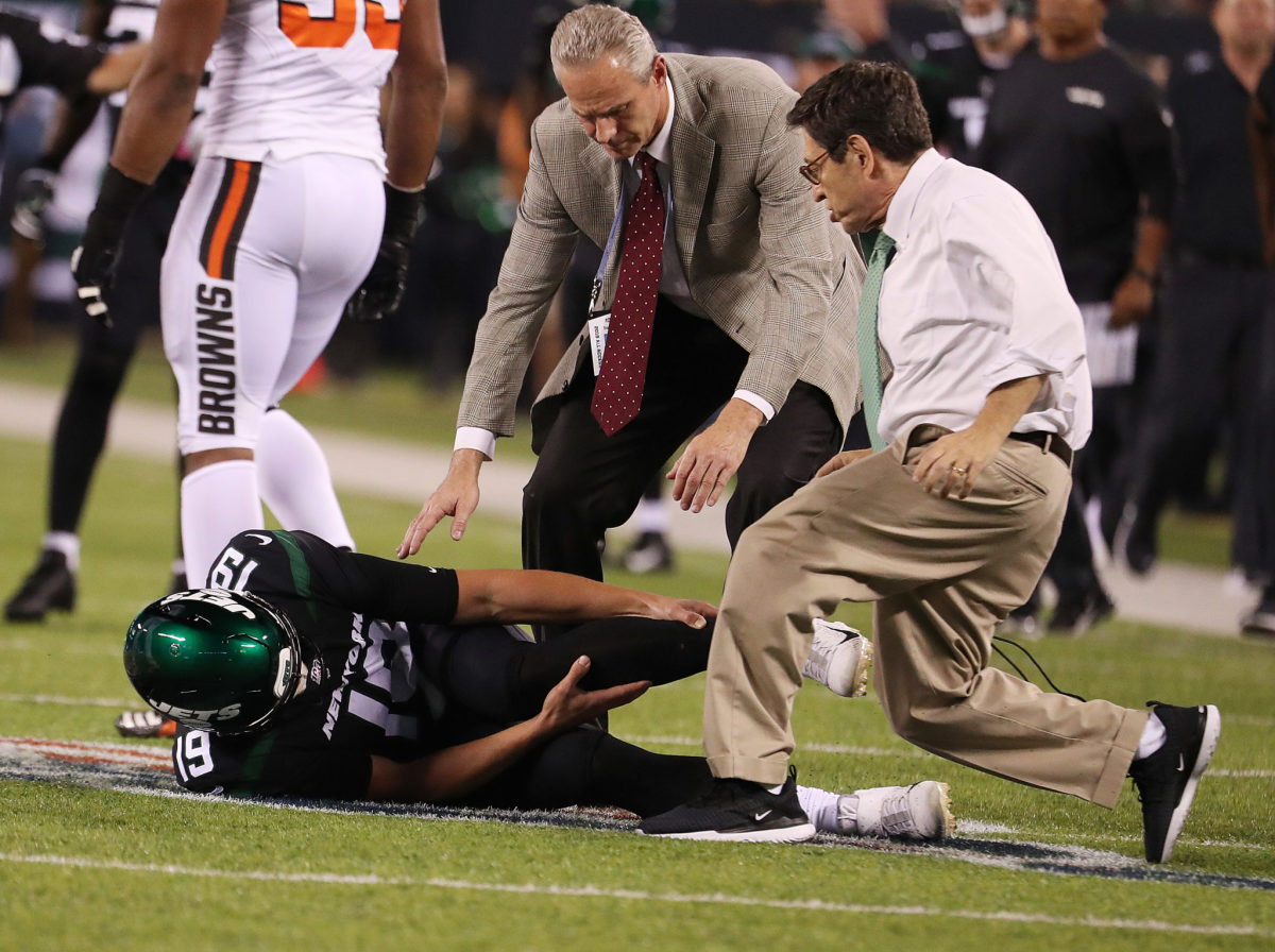 Trevor Siemian lies on the field grabbing his leg after being hurt.