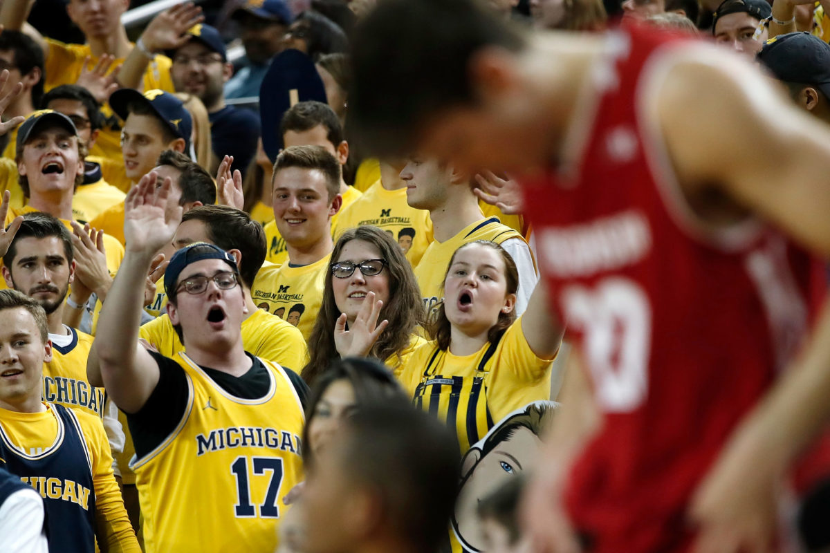 Michigan basketball fans cheering during a game.
