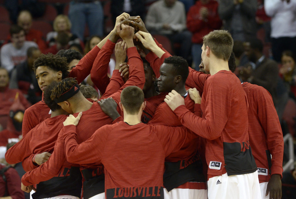 Louisville basketball's players huddle up before a game.