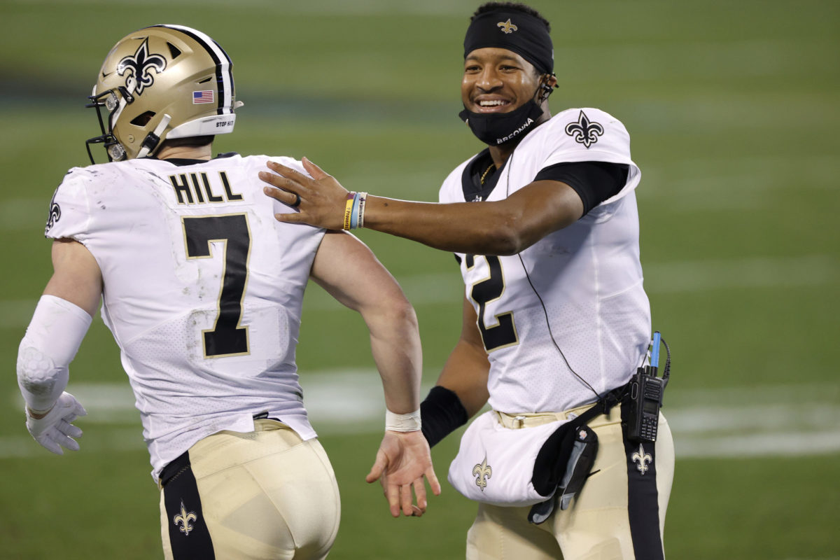 Jameis Winston and Taysom Hill celebrating a New Orleans Saints play.