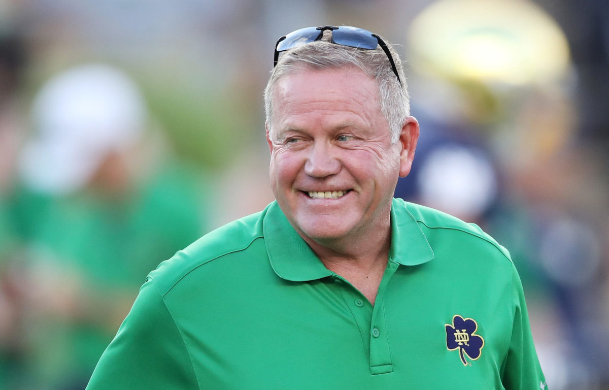 A closeup of Brian Kelly smiling during a Notre Dame football game.