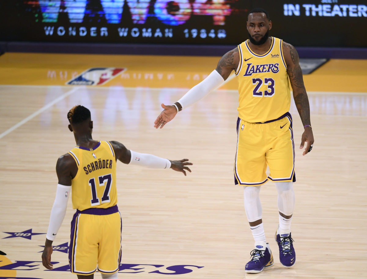 LeBron James daps up new Los Angeles Lakers teammate Dennis Schroder during early 2020-21 game.