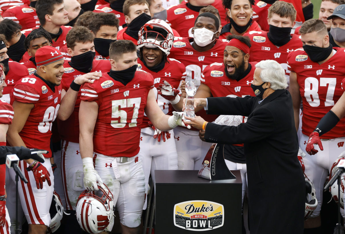 Wisconsin players receiving a trophy for winning the Duke's Mayo Bowl.