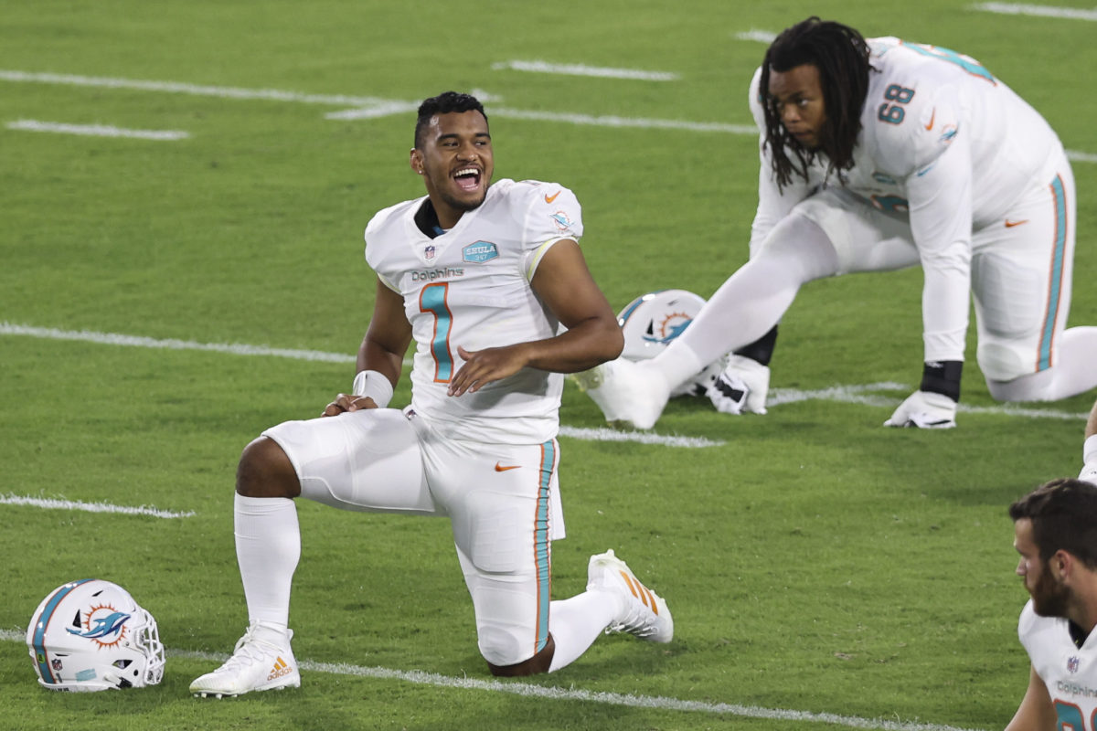 Tua Tagovailoa stretches on the field before a Miami Dolphins game.