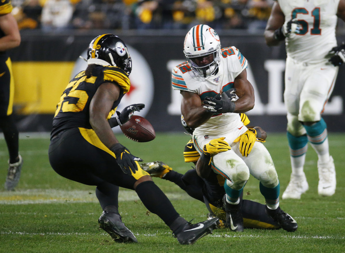 Mark Walton is stripped by Miami Dolphins DB Bobby McCain during a game.