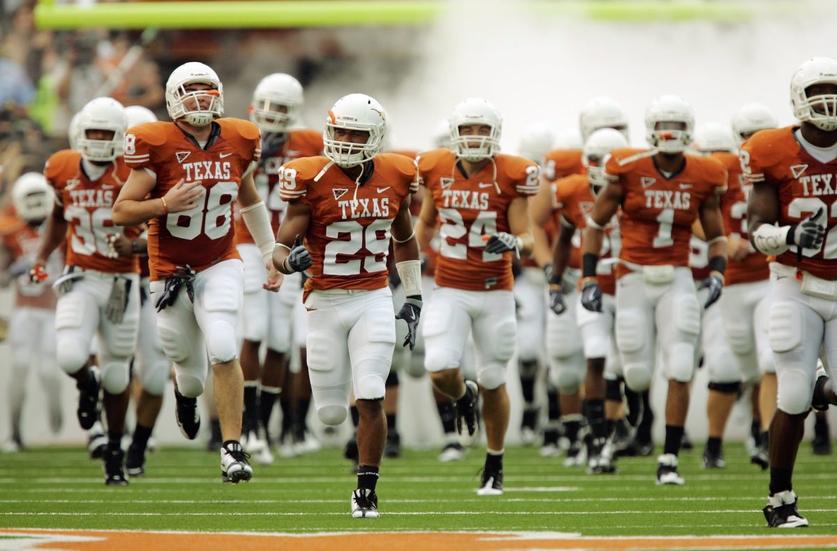 The Texas Longhorns football team running onto the field.
