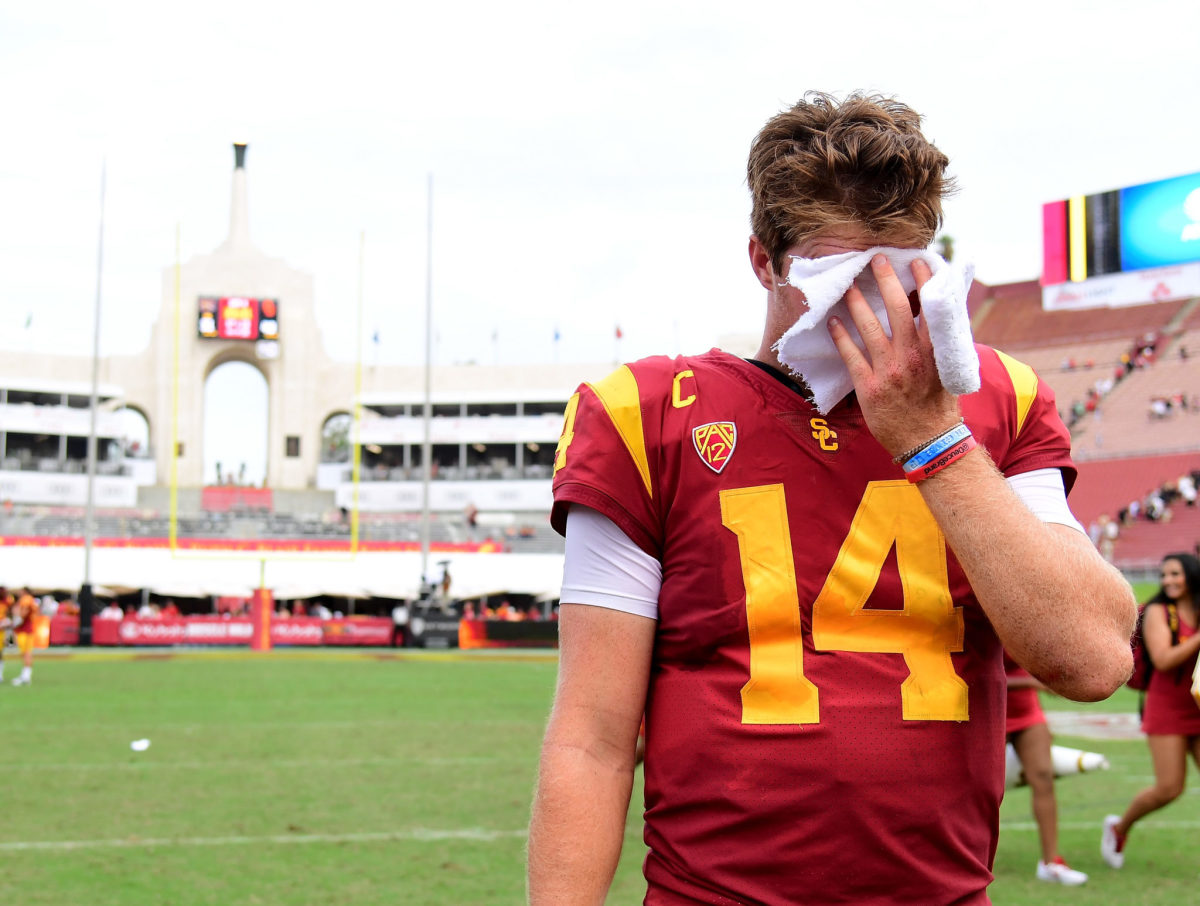 Sam Darnold wiping his face with a towel.