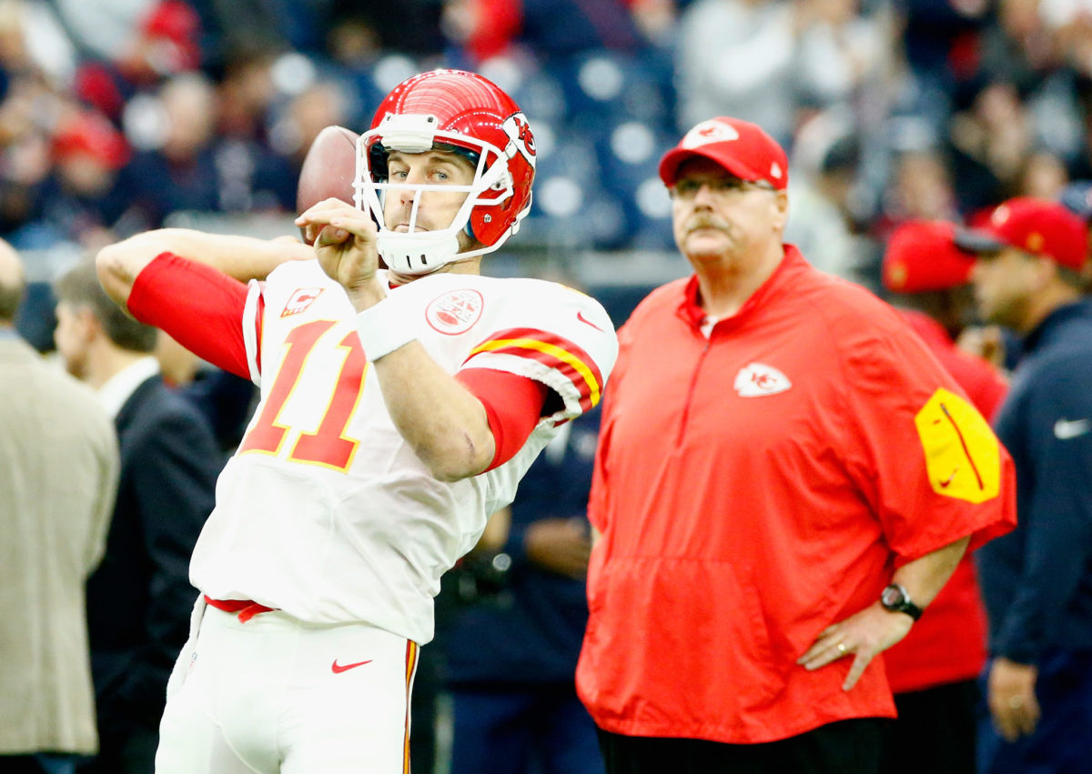 Alex Smith throws the ball before a game while Andy Reid looks on.