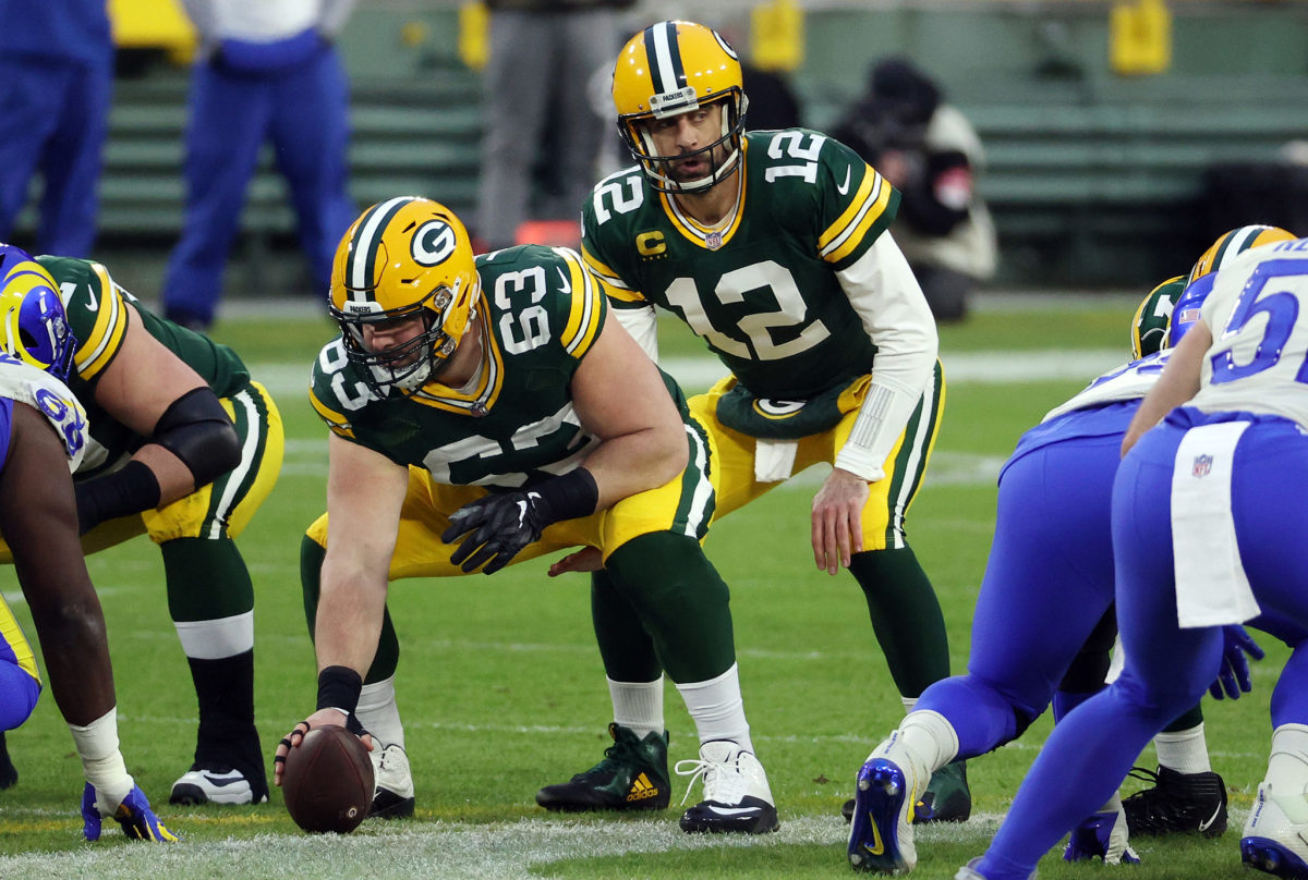 Aaron Rodgers take a snap from Corey Linsley.