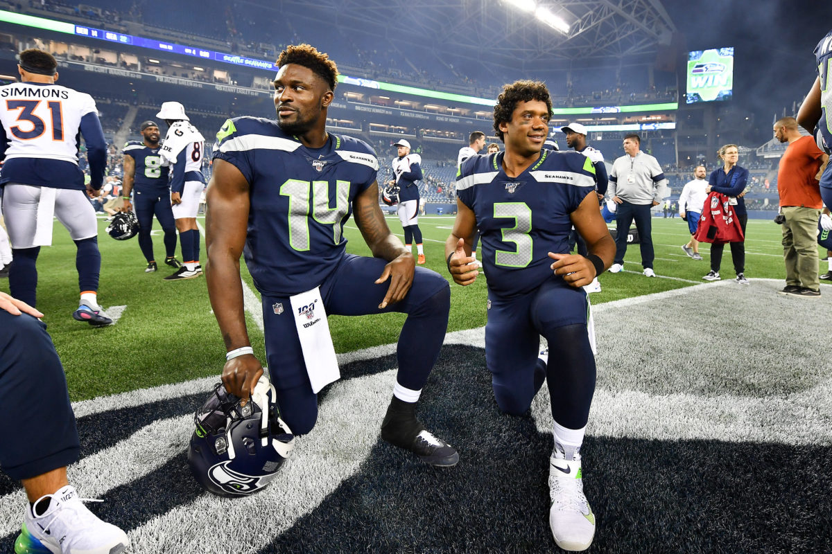 D.K. Metcalf #14 and Russell Wilson #3 of the Seattle Seahawks take a knee