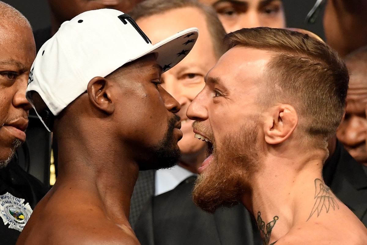 Conor McGregor and Floyd Mayweather standing face to face.
