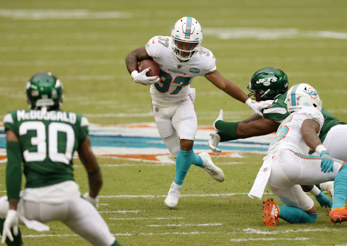 Miami Dolphins running back Myles Gaskin (37) is taken down by New England  Patriots cornerback Joejuan Williams (33) during the second half of an NFL  football game, Sunday, Sept. 12, 2021, in