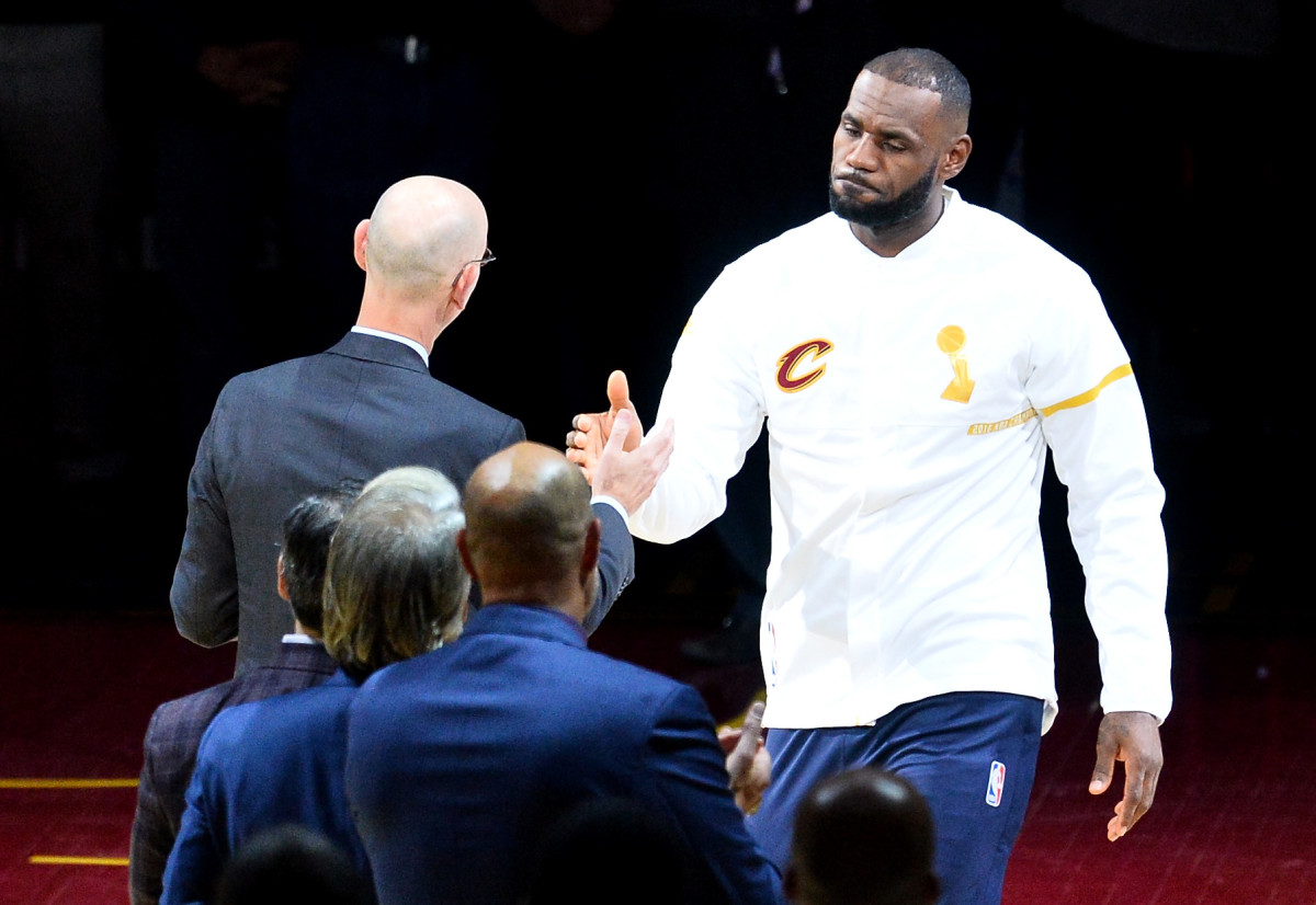 LeBron James and Adam Silver embrace during NBA game.